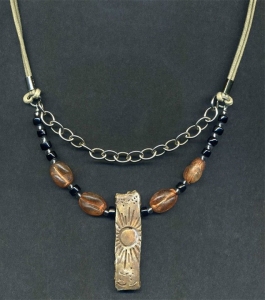 Necklace with rectangular sun pendant.