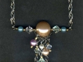 Necklace on chain with large faux pearl bead and faux pearl and crystal dangles.