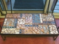 Mosaic shelf made to go on the bottom level of an aquarium stand. Most of the tiles are handmade by me, there are a few salvaged ones in there.