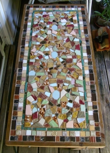 Here is a mosaic table using salvaged tiles and ones that I made. My garden soil has a lot of construction debris in it - I dug up quite a few of these tiles! My Dad built the table for me out of scrap wood.